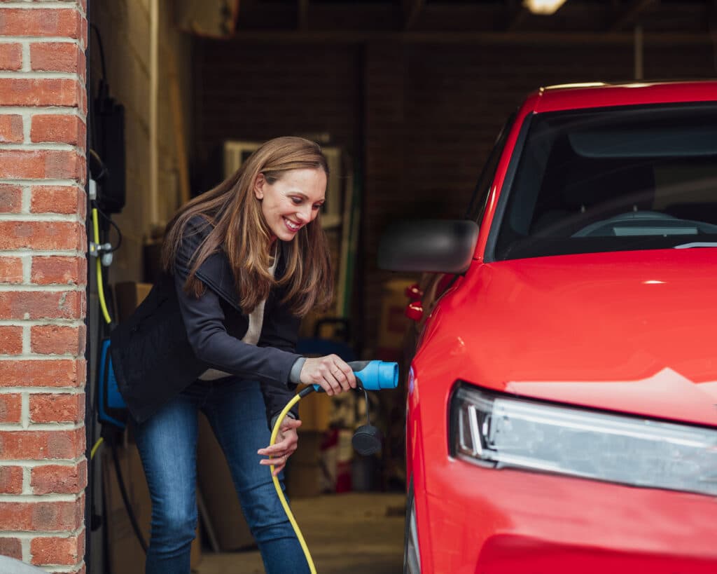 Woman charging her red Electric Vehicle