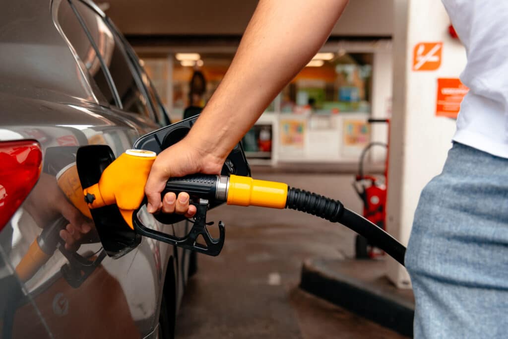 Young man, filling his gas tank with premium gasoline