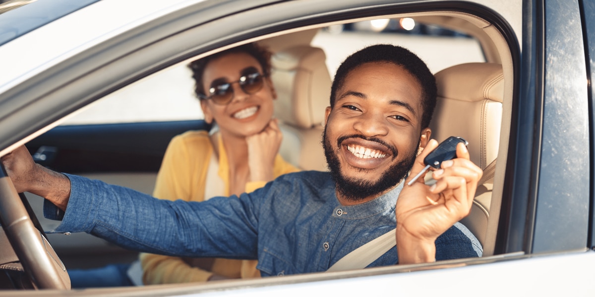 What to look for when buying a used car - happy looking couple after buying a used new car