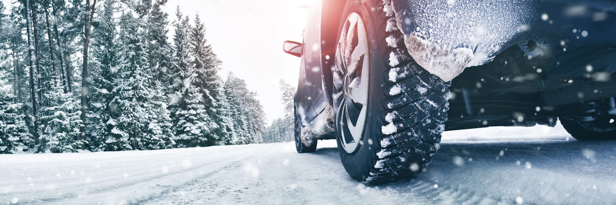 Closeup of car tires in winter on the road covered with snow.