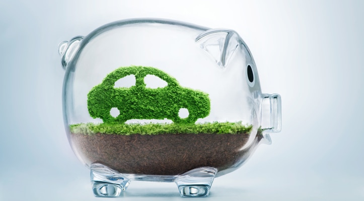 Green Car in clear piggy bank showing symbolizing EV Savings