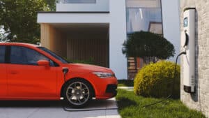 An electric car charging in a driveway